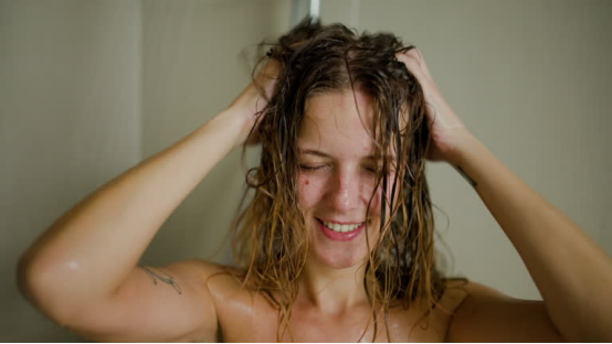 A woman with wet, frizzy hair in the shower, illustrating the humidity-related hair challenges a hair wax stick can solve.