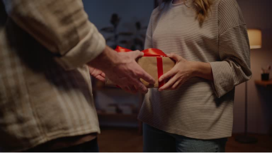 A person receiving a gift-wrapped box, representing the natural hair wax stick trio as a thoughtful, practical gift for hair care enthusiasts.